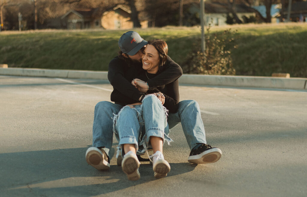 man and woman riding a longboard together during a sunset