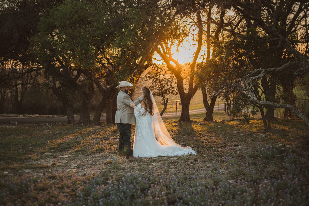 A bride and groom standing in the glow of a Texas Hill County sunset