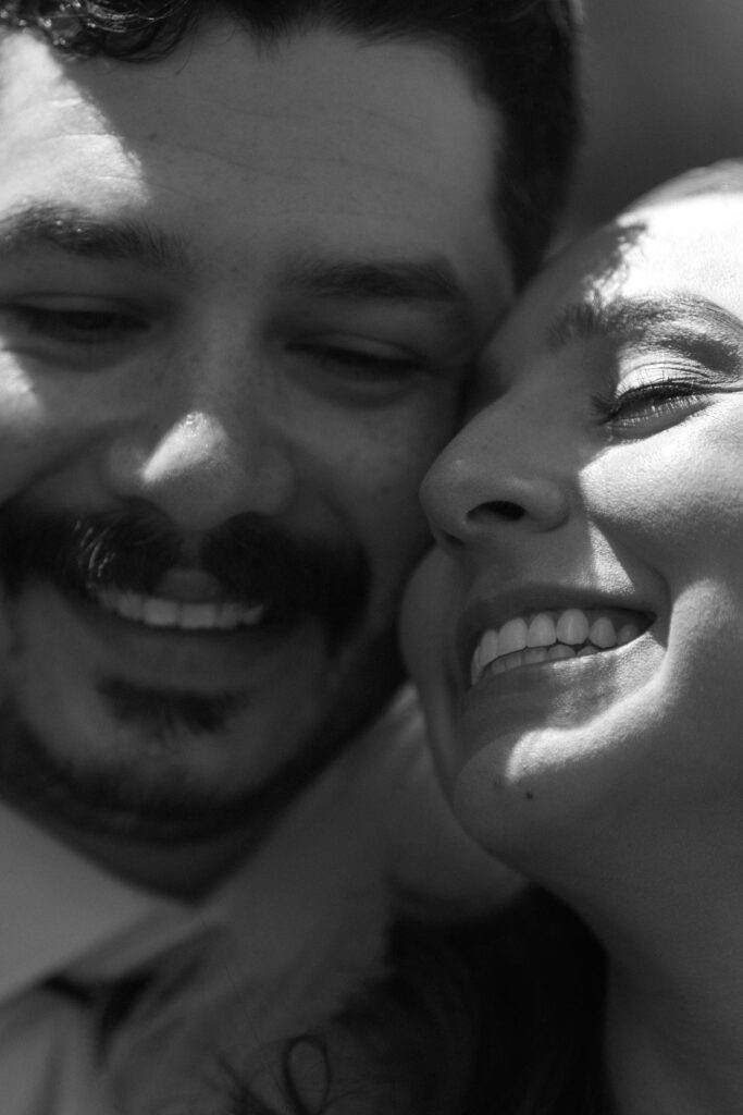 black and white photo of a groom and bride touching faces