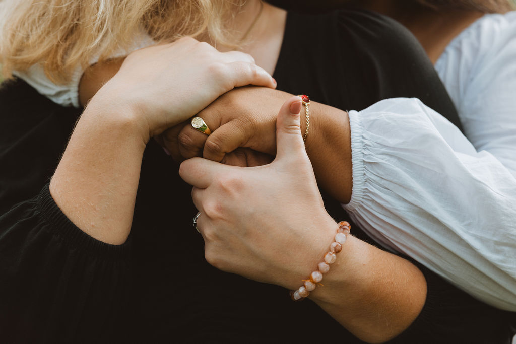 A close up on hands holding each other across someone's chest