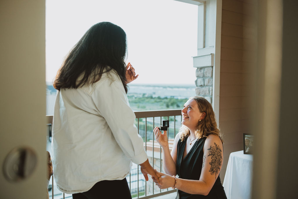 A proposal between two women being held private on a balcony outside of their home.