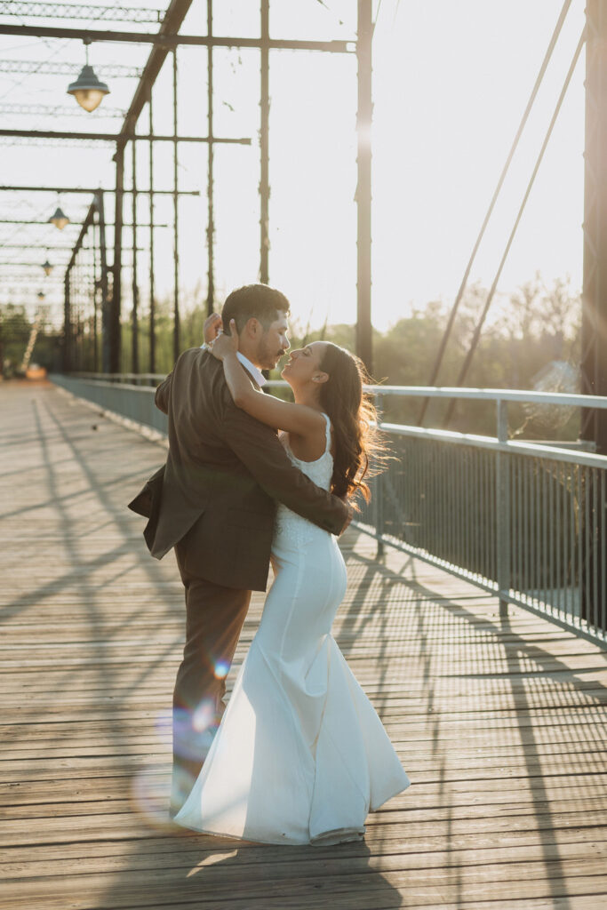 Bride and Groom dance during sunset and a bridge