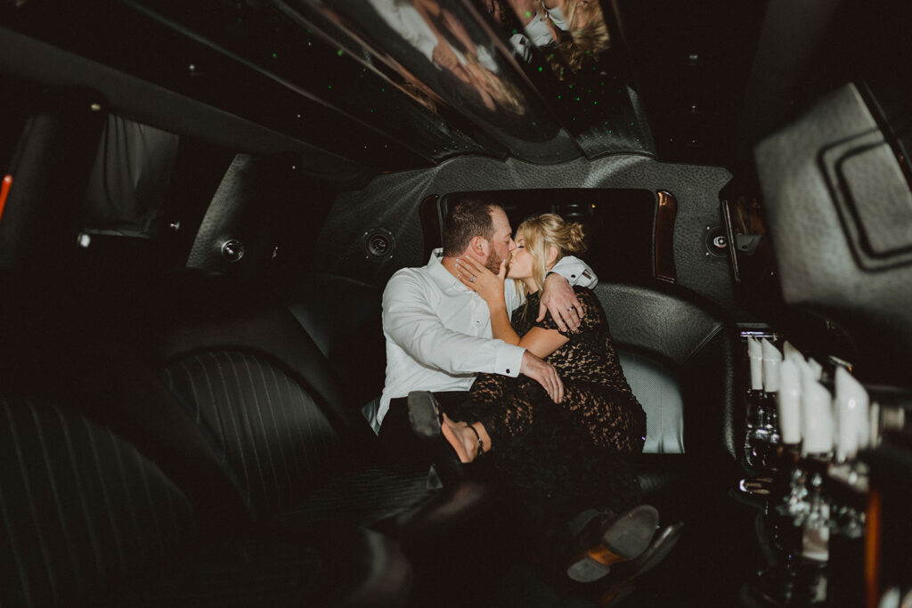 a bride and groom sharing a kiss in a dark limo