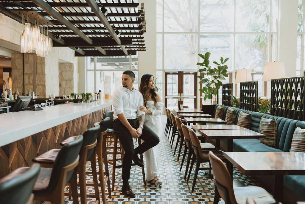 A couple poses in a modern bar setting