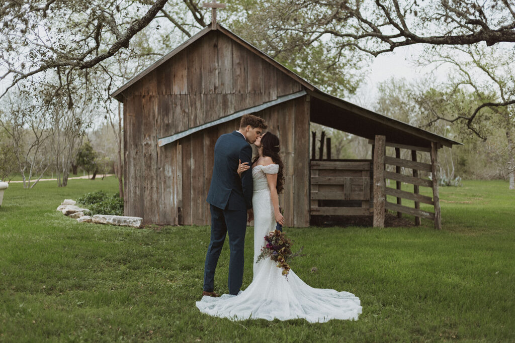 An editorial wedding photo of a couple with a moody bouquet in the bride's hand