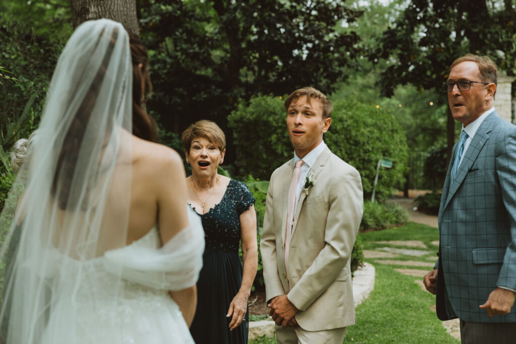 A bride's family reacting to seeing the bride for the first time during their first look