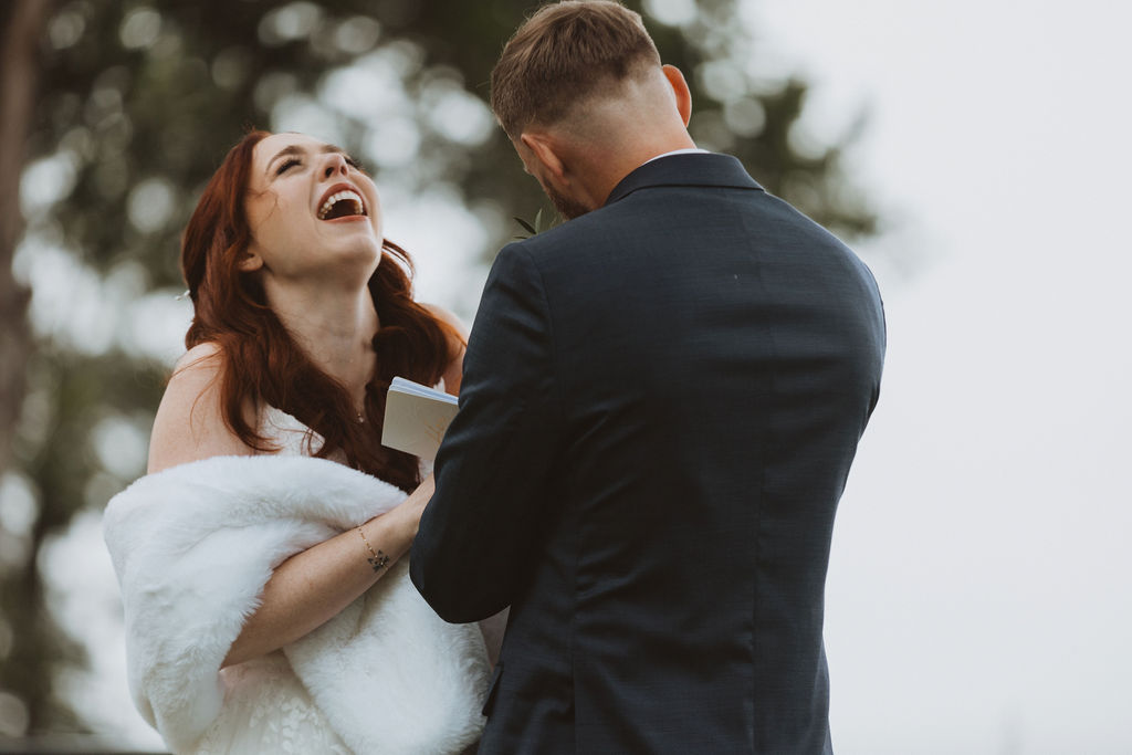 A bride laughing during a first look with her groom